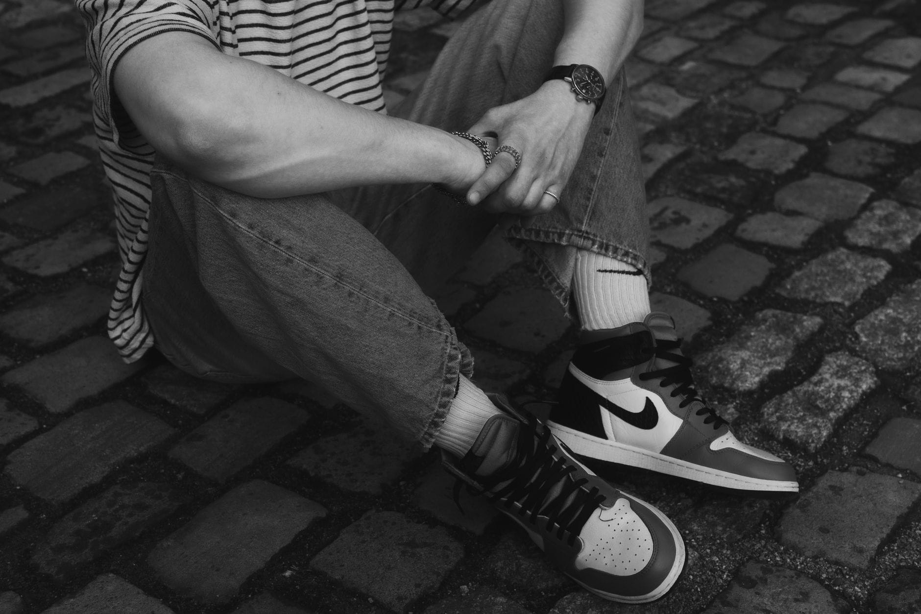 Czarno-białe zdjęcie osoby w Nike na brukowanej ulicy