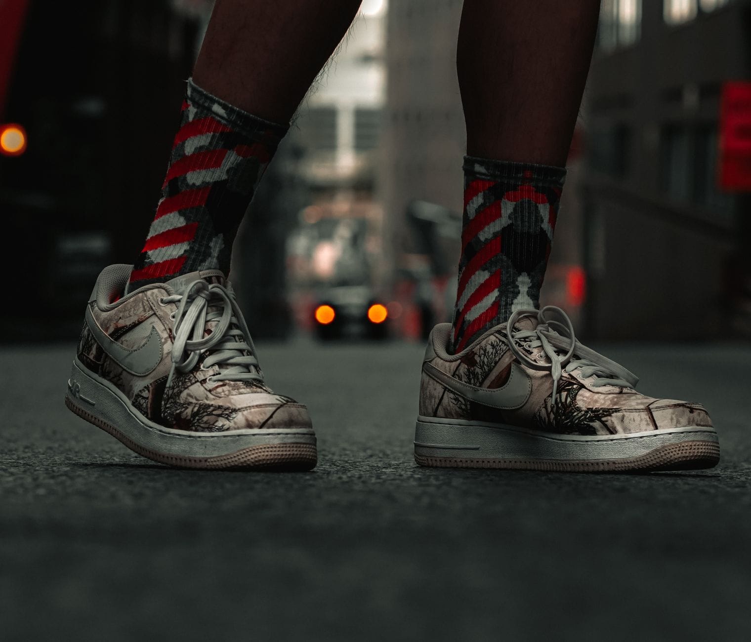 Modne sneakersy z widocznym logo na tle miejskiej ulicy